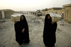 Iraqi women walk off after receiving boxes of food from Iraqi soldiers during a combined humanitarian aid mission in Muhalla 456 of Ghazaliyah, Iraq, on Sept. 6, 2008.