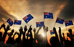 Sunset photo of a group of people waving Australian flags 
