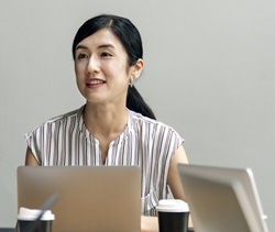 Asian female in office with laptop 