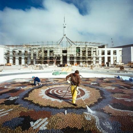 A construction worker hosing the completed Michael Nelson Jagamara mosaic in Forecourt of Parliament House; Philip Quike, Parliament House Art Collection.