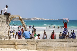 Mogadishu, Somalia: In a photo taken 09 November and released by the African Union-United Nations Information Support Team 10 November, a Somali boy holds a shirt aloft to dry in the wind at Lido Beach in the Abdul-Aziz district of the Somali capital Mogadishu.
