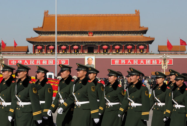Members of the PLA walk past Tiananmen Gate 