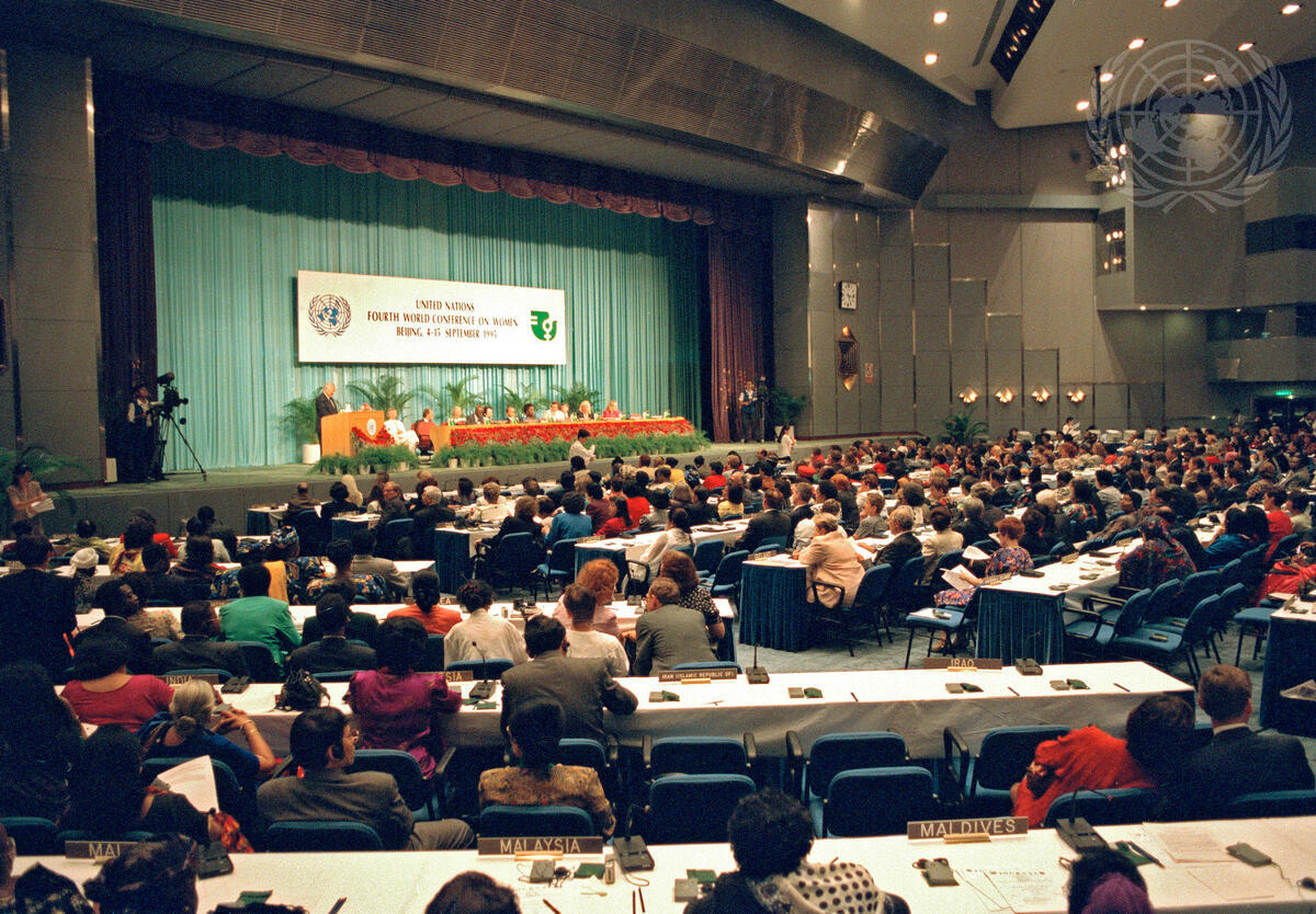 People in a conference room viewing a panel on a stage