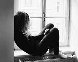 Black and white photograph of depressed teenage girl