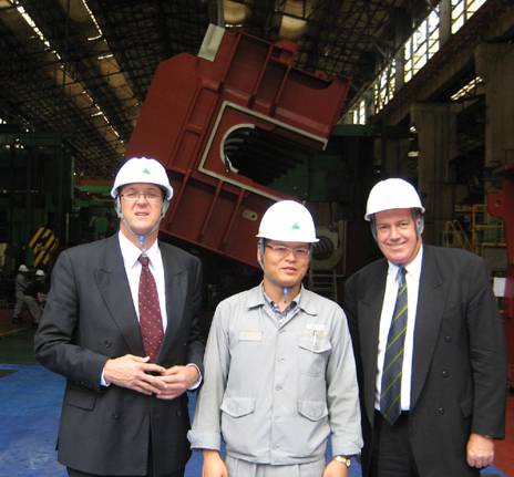 The delegation visited Hyundai Heavy Industries' shipyard at Ulsan and inspected HHI's engine manufacturing plant. An engine block hangs from the hall roof behind the delegation.